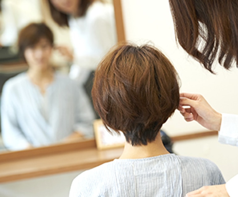 歯科医が診察ユニットに寝転んでいる女の子を診察している写真